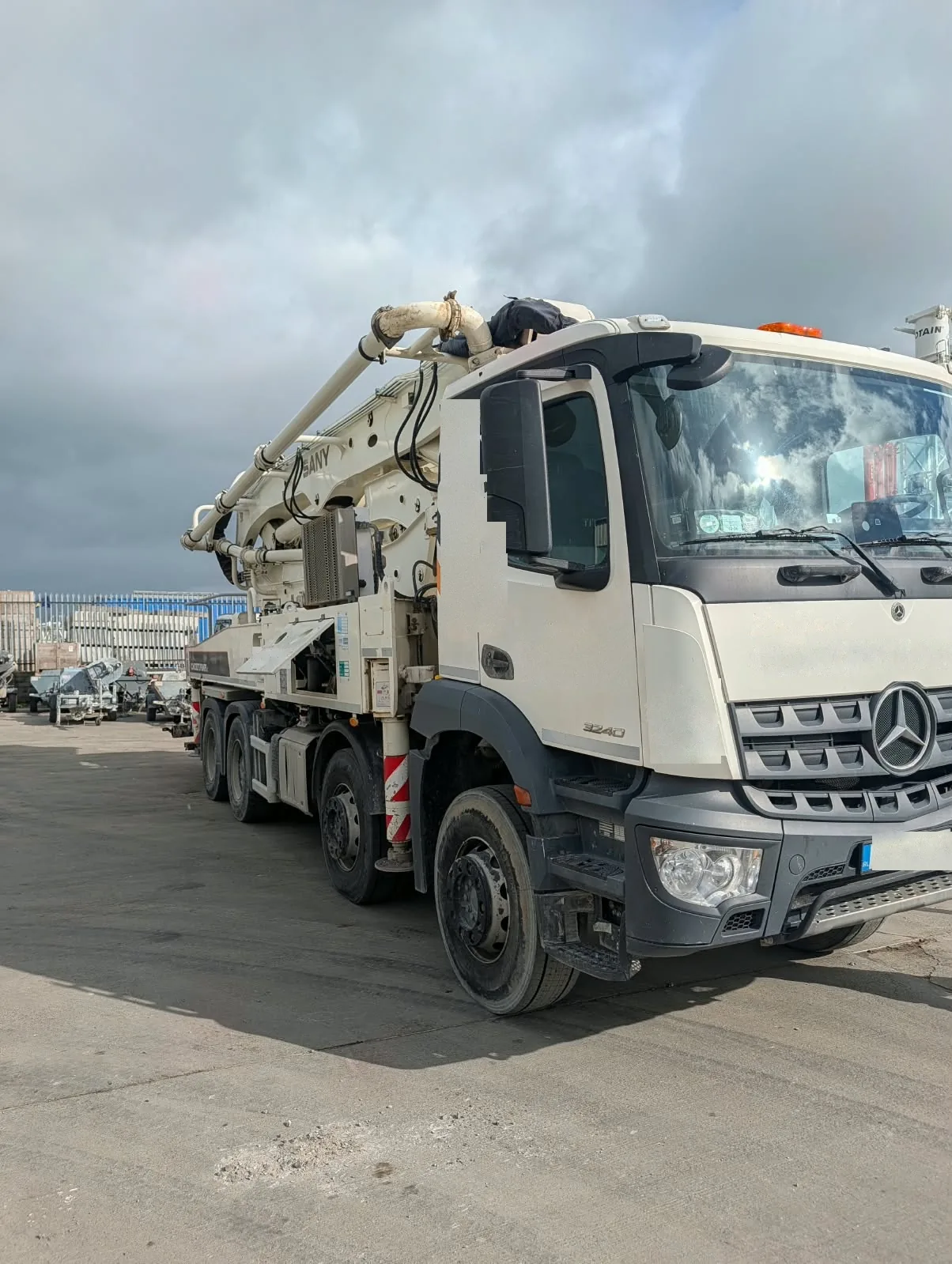 Sany truck-mounted concrete boom pump with the boom folded over the cab.